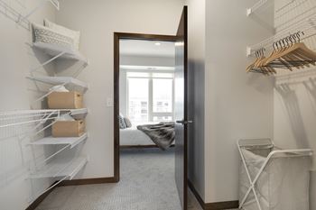 a walk in closet with a mirror and a door to a bedroom